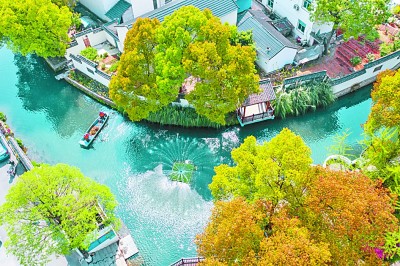 浙江省长兴县龙山街道渚山村的保洁人员乘船清理河面漂浮物。新华社发